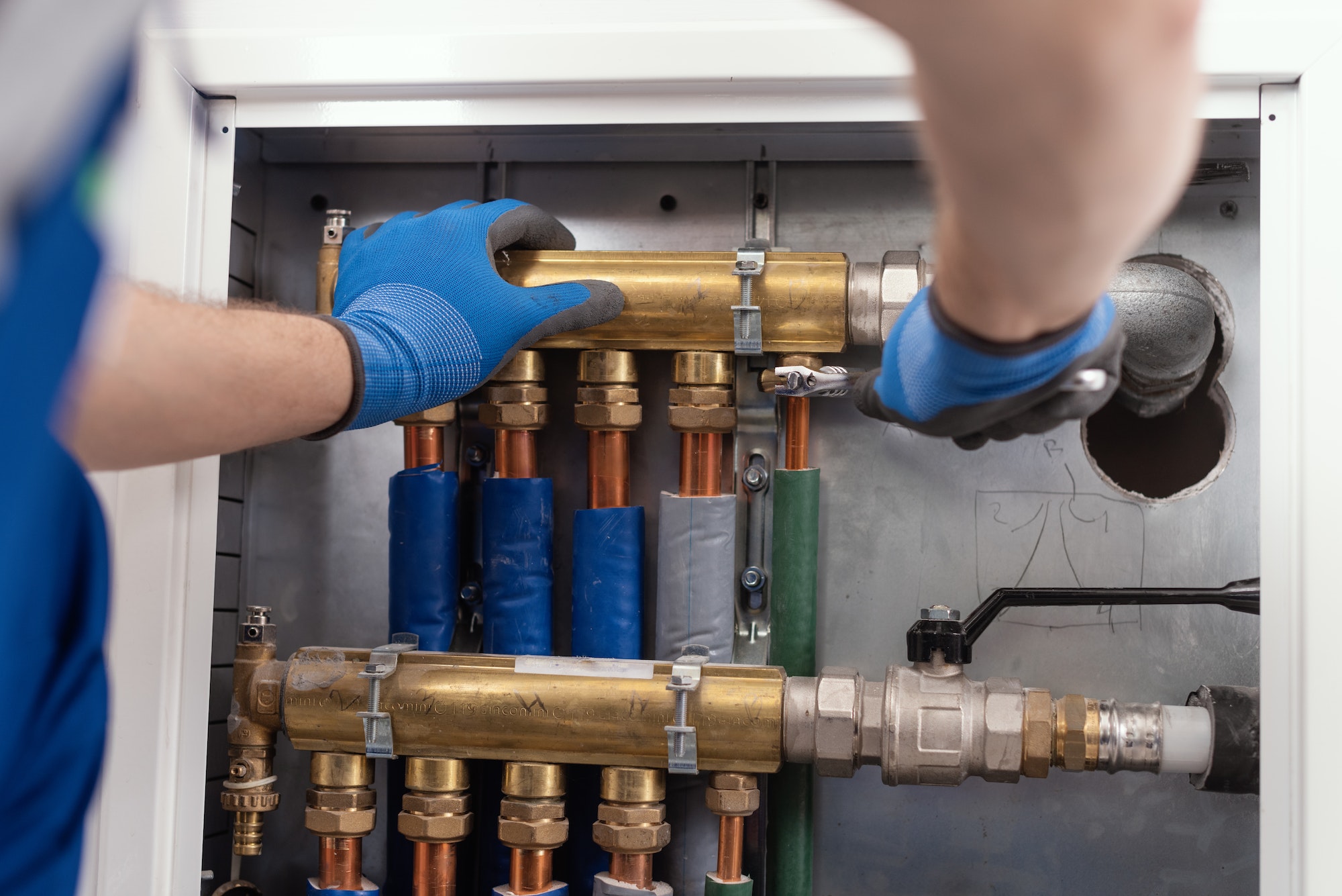 Professional plumber installing plumbing manifolds