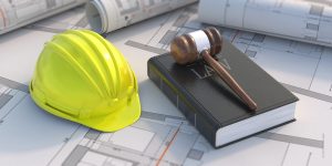 Construction, labor law concept. Judge gavel and book on project blueprint background.