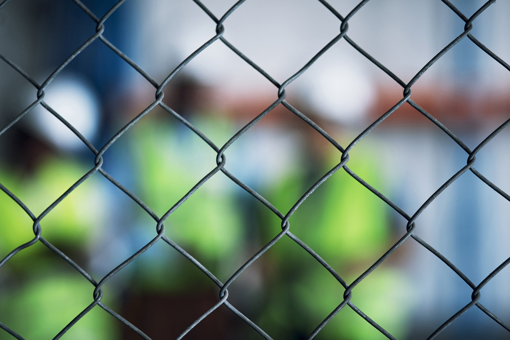 Shot of a group of unrecognisable builders inspecting a construction site behind a fence